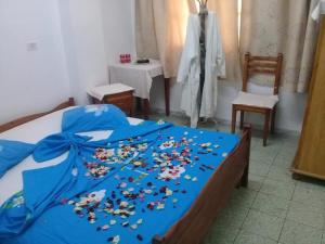 比塞大Hotel de la plage的一张床上,床上有鲜花,有蓝色的毯子