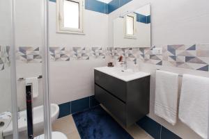 雷焦卡拉布里亚Showroom Luxury B&B的一间带水槽、卫生间和镜子的浴室