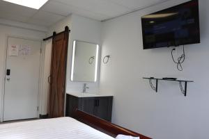 圣热罗姆AMR Hotel Inc的卧室配有一张床,墙上配有电视。