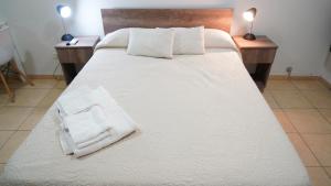 巴拉那AP138 8b Departamento micro Centro Paraná的一张配有白色床单和毛巾的大床