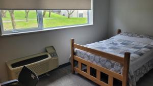 布罗克维尔Residence & Conference Centre - Brockville的一间卧室设有一张床和一个窗口