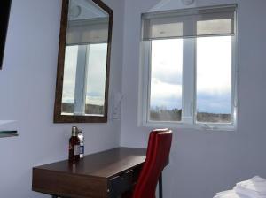 圣热罗姆AMR Hotel Inc的客房设有带镜子的书桌和红色椅子