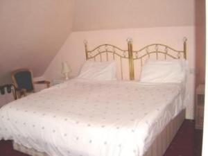 剑桥阿尔法米尔顿宾馆的卧室配有白色的床和木制床头板