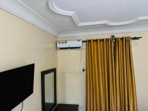 NnewiHavilah Suites Ltd, Nnewi的一间设有窗帘和镜子的天花板客房