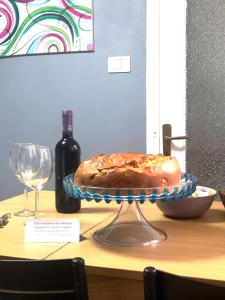佩特拉利亚索普拉纳Casa Vacanze A Tramuntana的一瓶葡萄酒和一张桌子上的蛋糕