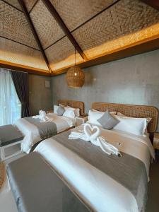 CavintiSofia's Lake Resort的一间卧室配有两张床和白色毛巾。