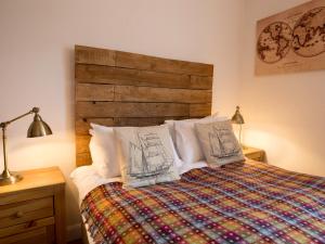 安布尔塞德4 Fir Garth的一间卧室配有一张带木制床头板的床