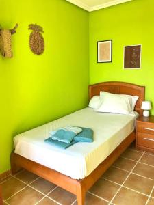 洛雷多Dúplex luminoso en Loredo con plaza de garaje的绿色卧室,配有一张带绿色墙壁的床
