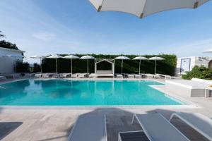 普罗奇达海狮住宿加早餐旅馆的一个带椅子和遮阳伞的游泳池