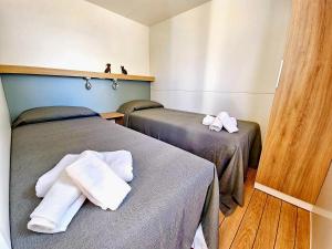 皮肖塔Villaggio Acquamarina的一间设有两张床铺和毛巾的房间