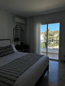 西迪·布·赛义德Misk Villa - Boutique Hotel & Spa的一间卧室设有一张床和一个大窗户