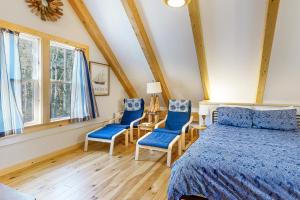 布斯贝港Cooper Cottage的一间卧室配有一张床和两张蓝色椅子
