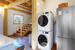 布斯贝港Cooper Cottage的厨房里配有洗衣机和烘干机,旁边是冰箱