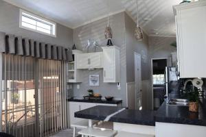 墨尔本比奇Tiny Home in Melbourne Beach的厨房配有白色橱柜和黑色台面