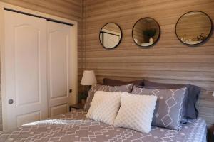 墨尔本比奇Tiny Home in Melbourne Beach的卧室配有一张带三面镜子的床铺。