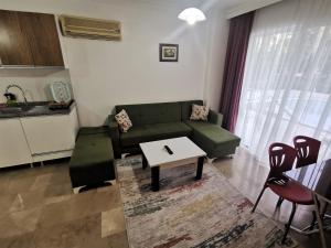 安塔利亚Maya Apart Antalya的客厅配有绿色沙发和桌子