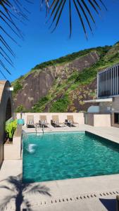 里约热内卢米拉多里约科帕卡巴纳酒店的一个带椅子的游泳池和一个山丘