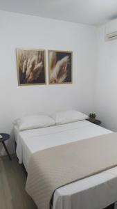 圣安热卢AP Confortável San Inácio的卧室内的两张床,墙上有两张照片
