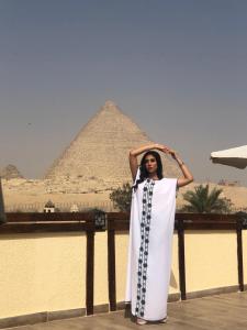 开罗Pyramids Era View的站在金字塔前的妇女