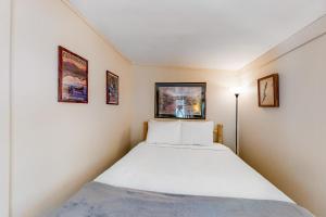 ChestertownRiver Road Retreat的一间小卧室,配有一张床和两张墙上的照片