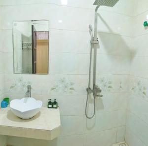 萨帕阮当住宿加早餐旅馆的白色的浴室设有水槽和淋浴。