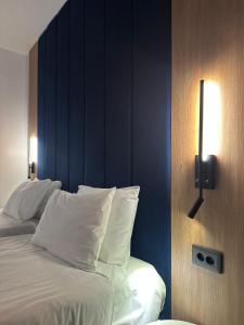 波亚纳布拉索夫Hotel Soimul的一张带白色枕头和蓝色墙壁的床
