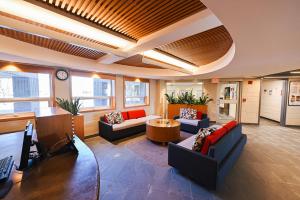金斯顿Residence & Conference Centre - Kingston的带沙发、桌子和时钟的办公大厅