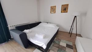 斯科普里Vera City Square Apartment的一间卧室配有带白色床单和毛巾的床。