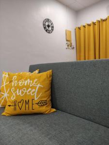 阿罗士打Maileyna Homestay 1.0的沙发上的黄色枕头,带有家庭甜蜜的家居标志