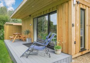 ToppesfieldCity to Country Retreat Luxury Lodges with Hot Tub, BBQ, Fire Pit的坐在房子旁边的甲板上的一对椅子