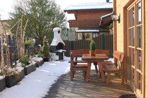 尼德恩西尔Alpen Chalets Zell am See的一个带桌子和长凳的雪地庭院