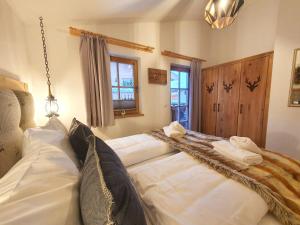 尼德恩西尔Alpen Chalets Zell am See的一张配有白色床单和毛巾的大床