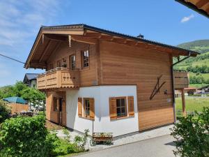 尼德恩西尔Alpen Chalets Zell am See的带阳台的小木房子