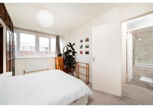 伦敦chic 3-BR home welll located in Islington的白色的卧室设有床和窗户