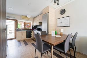 特勒克巴林特B48 Duplex的厨房以及带木桌和椅子的用餐室。