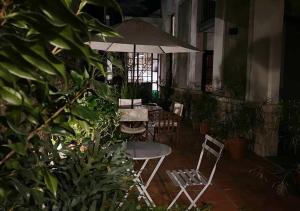 布宜诺斯艾利斯波萨达高登酒店的庭院配有桌椅和遮阳伞。