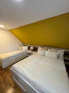 普拉伊德Casa Rustik Nyaraló的黄色墙壁的客房内的两张床