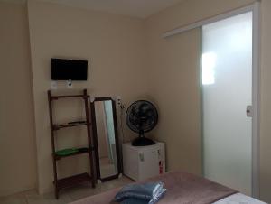 瓜拉派瑞HoStel de Setiba - HOSPEDARIA OCA RUCA的一间卧室配有一张床、风扇和镜子