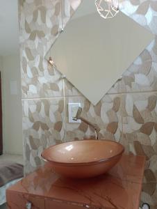 瓜拉派瑞HoStel de Setiba - HOSPEDARIA OCA RUCA的一间带桌子上的碗水槽的浴室