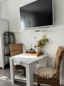 斯普利特Rooms Zana的一张带两把椅子的白色桌子和墙上的电视