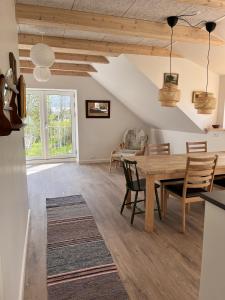 SkibbyNordgården - ferie på landet的用餐室以及带木桌和椅子的客厅。