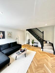 曼彻斯特Canal Mews的客厅设有黑色沙发和楼梯。