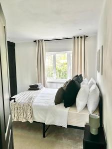 曼彻斯特Canal Mews的卧室配有带枕头的床铺和窗户。
