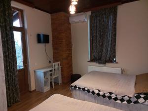 安布罗劳里Royal Edena的一间卧室设有两张床、一张桌子和一个窗口。