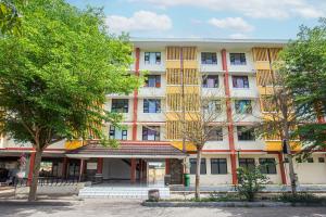 TjakranegaraOYO Life 93405 Montong Are Residence的公寓大楼前面有树木