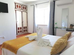 拉戈斯Marreiro's house Algarve - Child friendy - Private Pool的一间卧室配有一张带天鹅装饰的床。