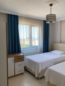 安曼Zamman Amman的一间卧室设有两张床,窗户配有蓝色窗帘