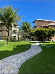 阿奎拉兹Beach Place Resort - Térreo的棕榈树公园和建筑中的步道