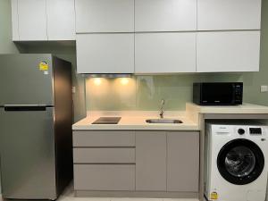 金边City View Studio Unit的厨房配有白色橱柜和洗衣机。