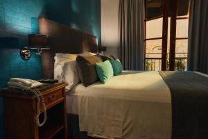 布宜诺斯艾利斯摩拉维亚苏豪酒店的一间卧室配有一张床,桌子上配有一部电话